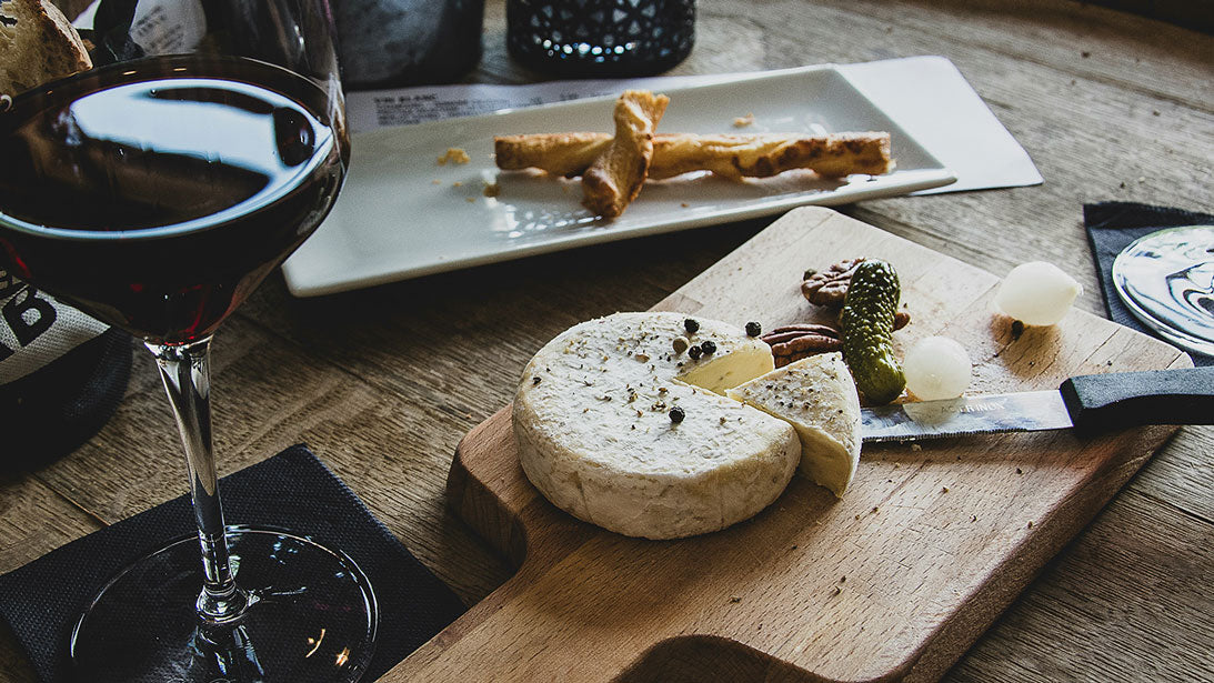 Plateau de fromages accompagné d'un verre de vin rouge